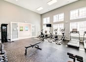 Thumbnail 49 of 53 - A spacious gym with a variety of equipment including treadmills, weights, and exercise machines.