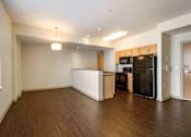 Thumbnail 3 of 16 - A kitchen with a black fridge and wooden cabinets.