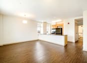 Thumbnail 4 of 16 - A spacious kitchen with a wooden floor and white walls.