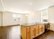 Thumbnail 5 of 16 - A kitchen with wooden cabinets and a black countertop.