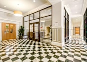 Thumbnail 13 of 16 - A hallway with a black and white checkered floor.