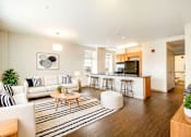 Thumbnail 1 of 16 - A modern living room with a white couch and a coffee table.