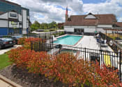 Thumbnail 30 of 32 - a swimming pool at a hotel with a building in the background