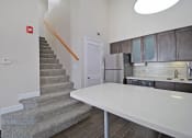 Thumbnail 22 of 32 - a kitchen with a white counter next to a stairwell