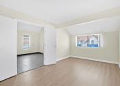 Thumbnail 18 of 32 - a spacious living room with wood flooring and white walls