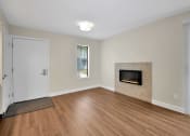 Thumbnail 15 of 32 - a living room with a fireplace and wooden floors