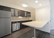Thumbnail 14 of 32 - a kitchen with a white counter top and a stainless steel refrigerator