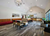 Thumbnail 28 of 32 - a dining room with tables and chairs and a kitchen in the background