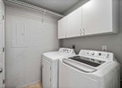 Thumbnail 13 of 24 - A white laundry room with a washer and dryer.