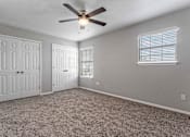 Thumbnail 10 of 24 - A room with a ceiling fan and two doors.