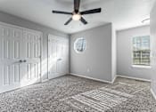 Thumbnail 6 of 24 - A room with a ceiling fan and a carpeted floor.