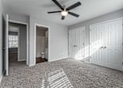 Thumbnail 9 of 24 - A room with a ceiling fan and three doors.