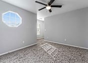 Thumbnail 7 of 24 - A room with a ceiling fan and a hexagonal window.