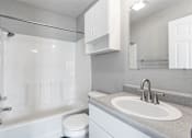 Thumbnail 12 of 24 - A white bathroom with a toilet, sink, and shower.