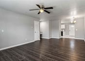 Thumbnail 17 of 24 - A room with a ceiling fan and wooden flooring.