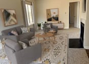 Thumbnail 5 of 32 - A living room with a grey couch and a coffee table.