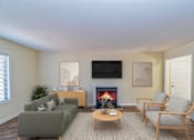 Thumbnail 1 of 32 - A living room with a fireplace and a television.