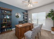 Thumbnail 10 of 25 - an office with blue walls and a large window and a desk with chairs