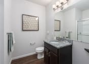 Thumbnail 11 of 25 - a bathroom with a sink and a toilet and a mirror