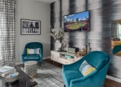 Thumbnail 23 of 25 - a living room with blue chairs and a tv on the wall