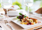 Thumbnail 11 of 11 - A white plate with a salad and a piece of meat on it.
