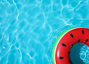 Thumbnail 6 of 11 - A watermelon-shaped float in a pool of water.