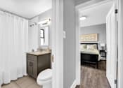 Thumbnail 11 of 44 - A bathroom with a toilet, sink, and shower curtain.
