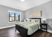 Thumbnail 15 of 44 - A bedroom with a large bed and a window overlooking a cityscape.