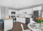 Thumbnail 1 of 44 - A modern kitchen with a dining table set for two.