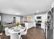 Thumbnail 4 of 44 - A modern kitchen with a dining table set for four.