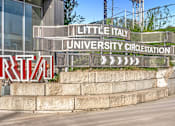 Thumbnail 21 of 44 - A sign for Little Italy University Circus Station is displayed in front of a building.