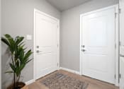 Thumbnail 9 of 24 - an empty room with two white doors and a potted plant