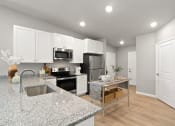 Thumbnail 2 of 24 - a renovated kitchen with granite counter tops and white cabinets