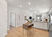 Thumbnail 7 of 24 - a kitchen with white cabinets and a table with a basket
