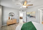 Thumbnail 11 of 24 - a bedroom with a bed and a ceiling fan