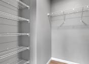 Thumbnail 17 of 24 - a spacious walk in closet in a home with empty shelves