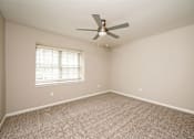 Thumbnail 10 of 15 - A room with a ceiling fan and a window with blinds.