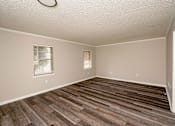 Thumbnail 7 of 15 - A room with wooden flooring and a window with blinds.