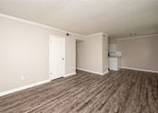 Thumbnail 4 of 15 - A room with wood flooring and a white door.