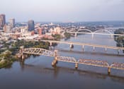 Thumbnail 15 of 15 - A bridge spans a river in a city with a skyline in the background.