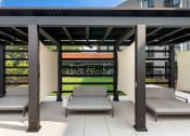 Thumbnail 34 of 82 - a pergola with two chaise lounges on a patio