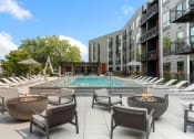 Thumbnail 36 of 82 - an outdoor pool with lounge chairs and fire pits