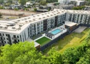 Thumbnail 74 of 82 - an aerial view of a large white building with a pool and tennis court in front of it
