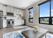 Thumbnail 19 of 82 - a kitchen with white cabinets and stainless steel appliances and a wooden table with a vase of