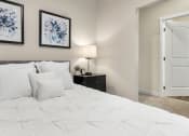 Thumbnail 22 of 82 - a bedroom with white bedding and two framed pictures on the wall