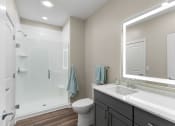 Thumbnail 23 of 82 - a bathroom with a large mirror and a shower with a glass door
