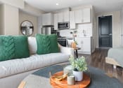 Thumbnail 14 of 82 - a living area with a couch coffee table and a kitchen in the background
