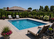 Thumbnail 4 of 4 - A pool surrounded by chairs and plants.