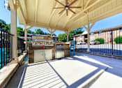 Thumbnail 21 of 24 - A covered walkway with a ceiling fan and a pool in the background.