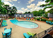 Thumbnail 19 of 24 - A pool surrounded by chairs and tables.